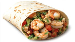 Close-up of a shrimp burrito, packed with shrimp, avocado, tomatoes, and herbs wrapped in a tortilla