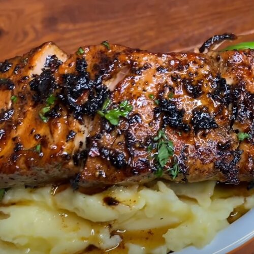 Seared salmon, perfectly seasoned, rests atop creamy mashed potatoes